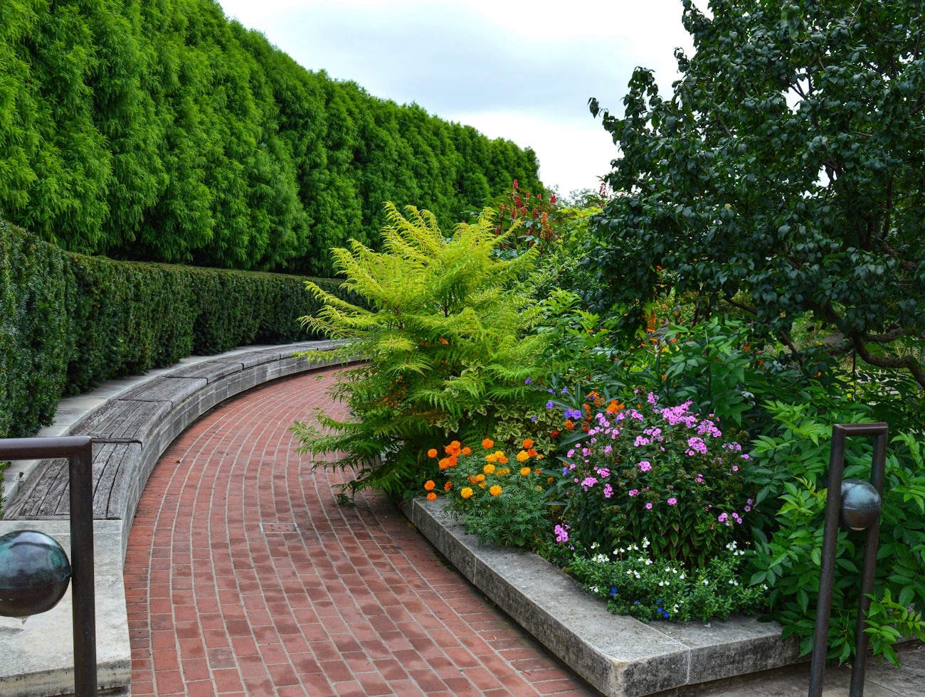 Curved brick raised planter filled with flowering plants